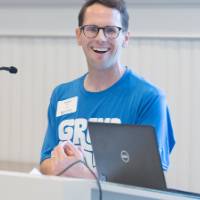 Andrew Bixel speaking at podium